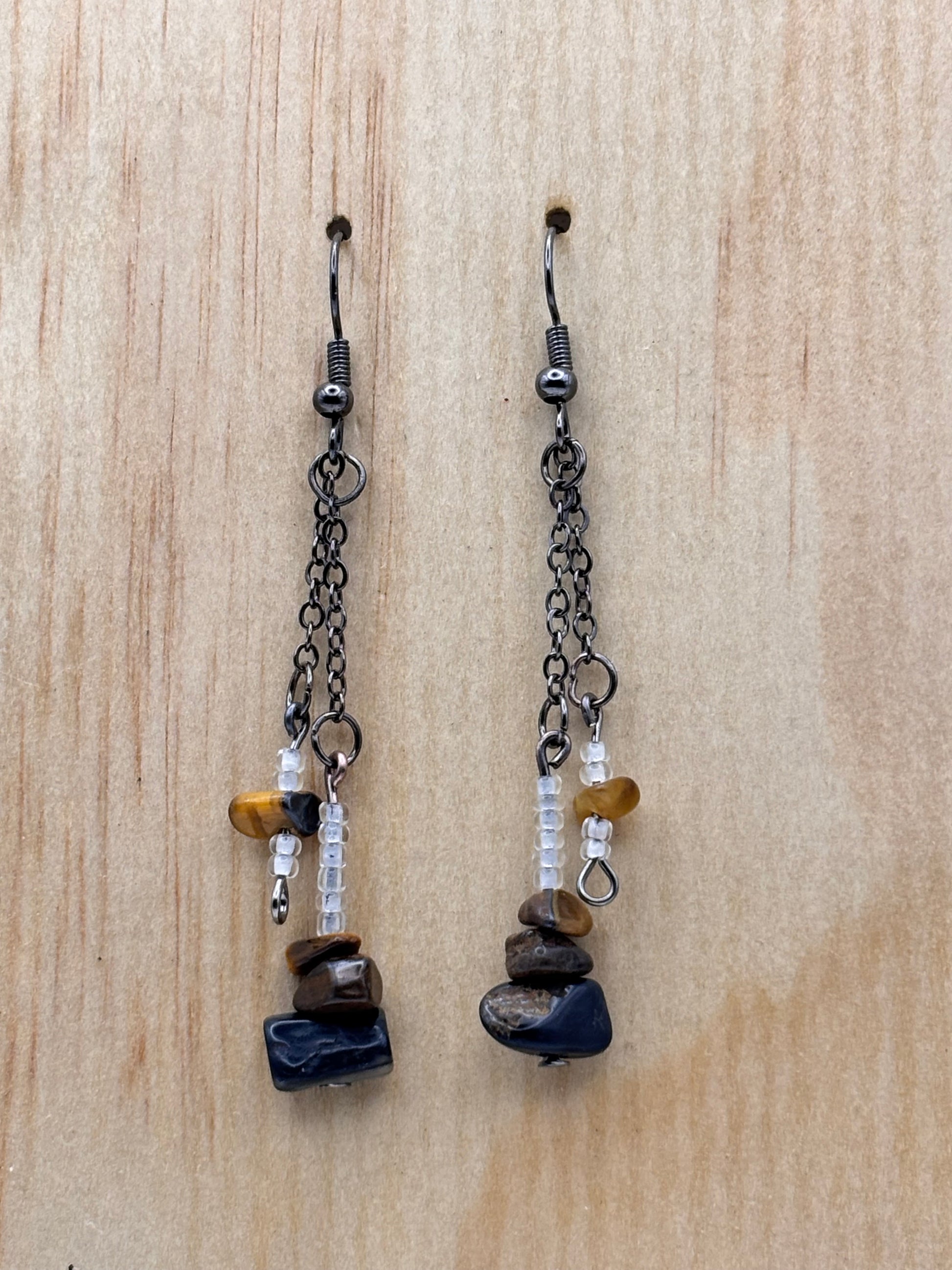 Two beaded chains with stones on a wooden surface