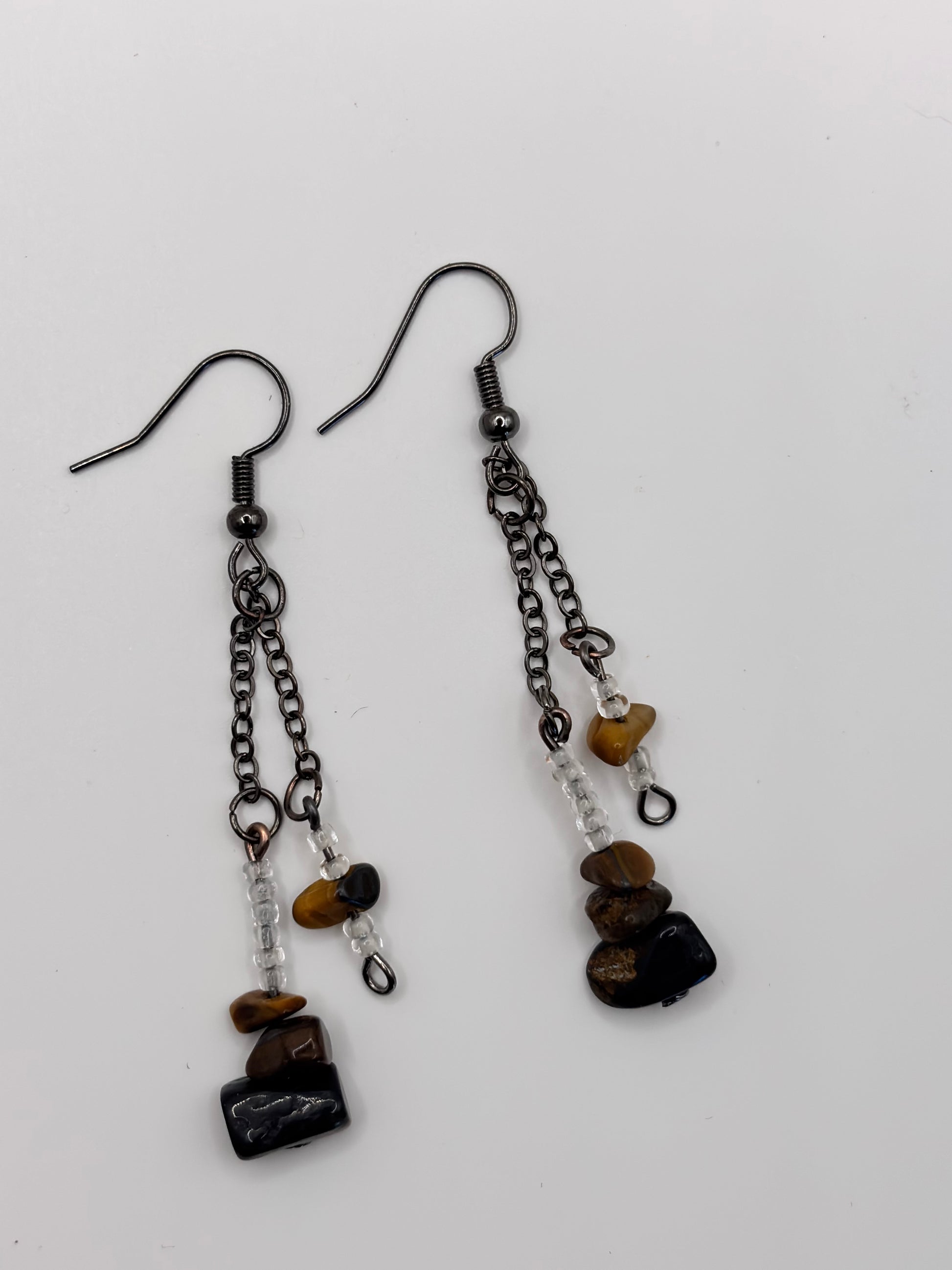 Pair of earrings with chain and stone components on a white background