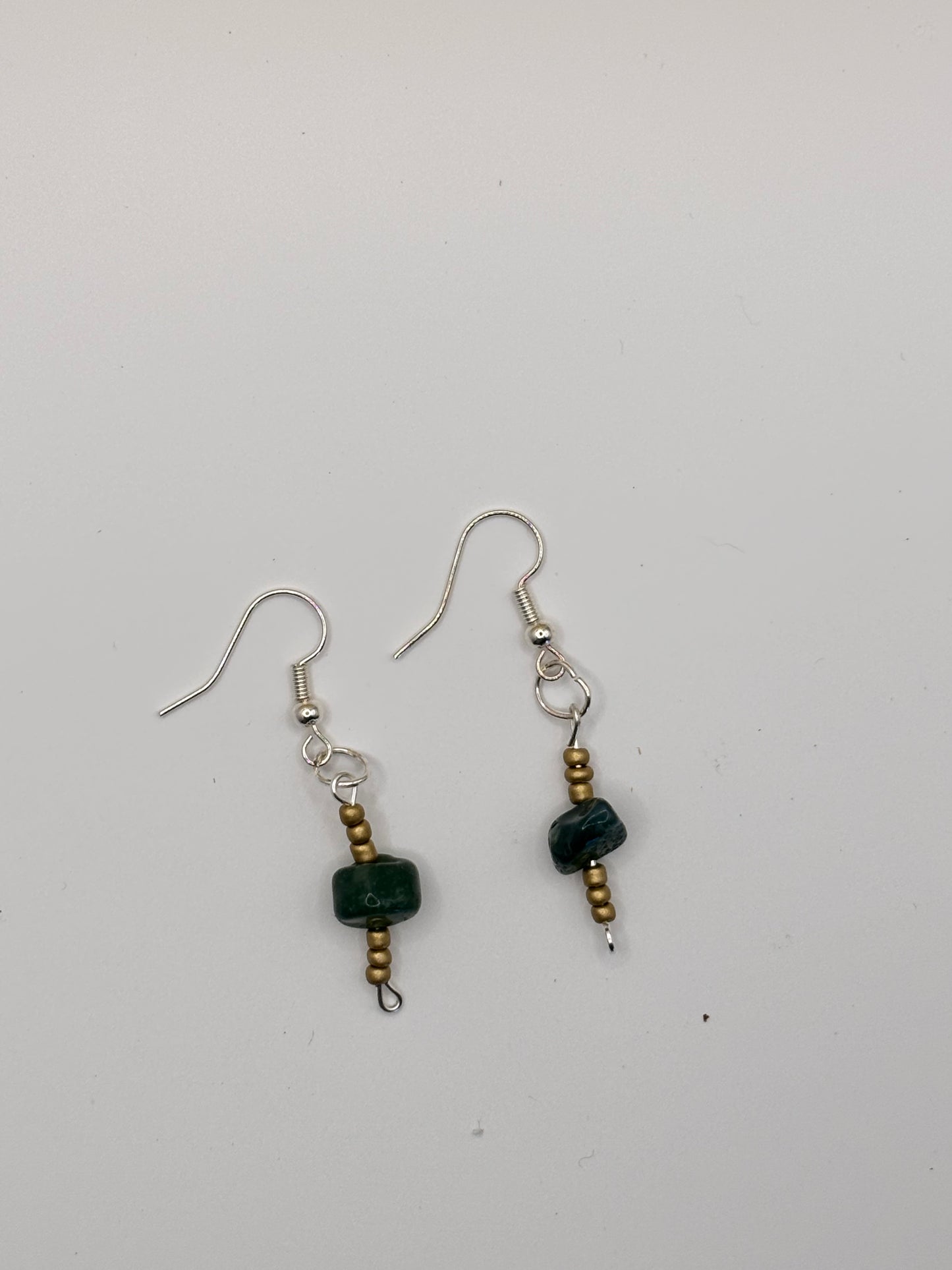 Pair of earrings with black beads on a white background