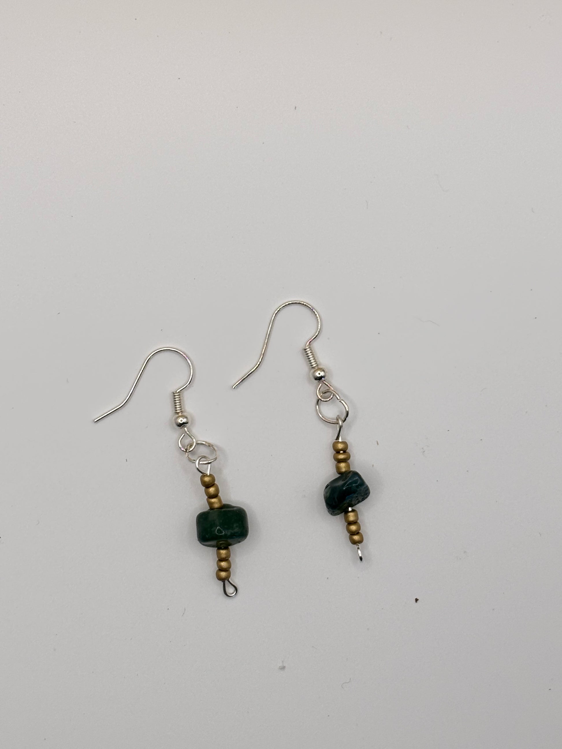 Pair of earrings with black beads on a white background