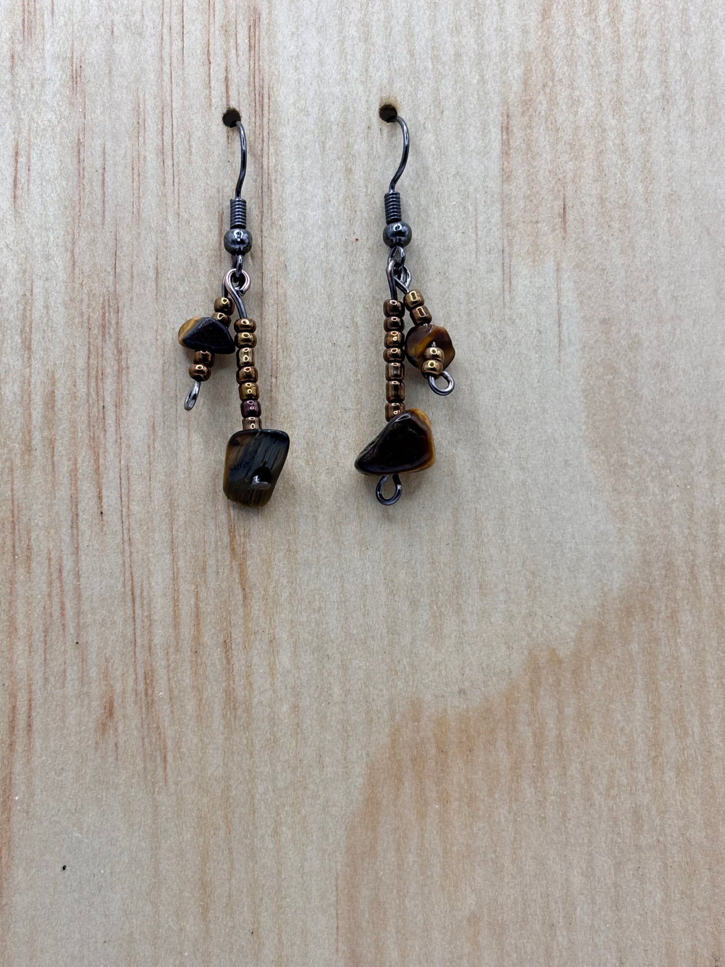 Pair of dangling earrings on a wooden surface