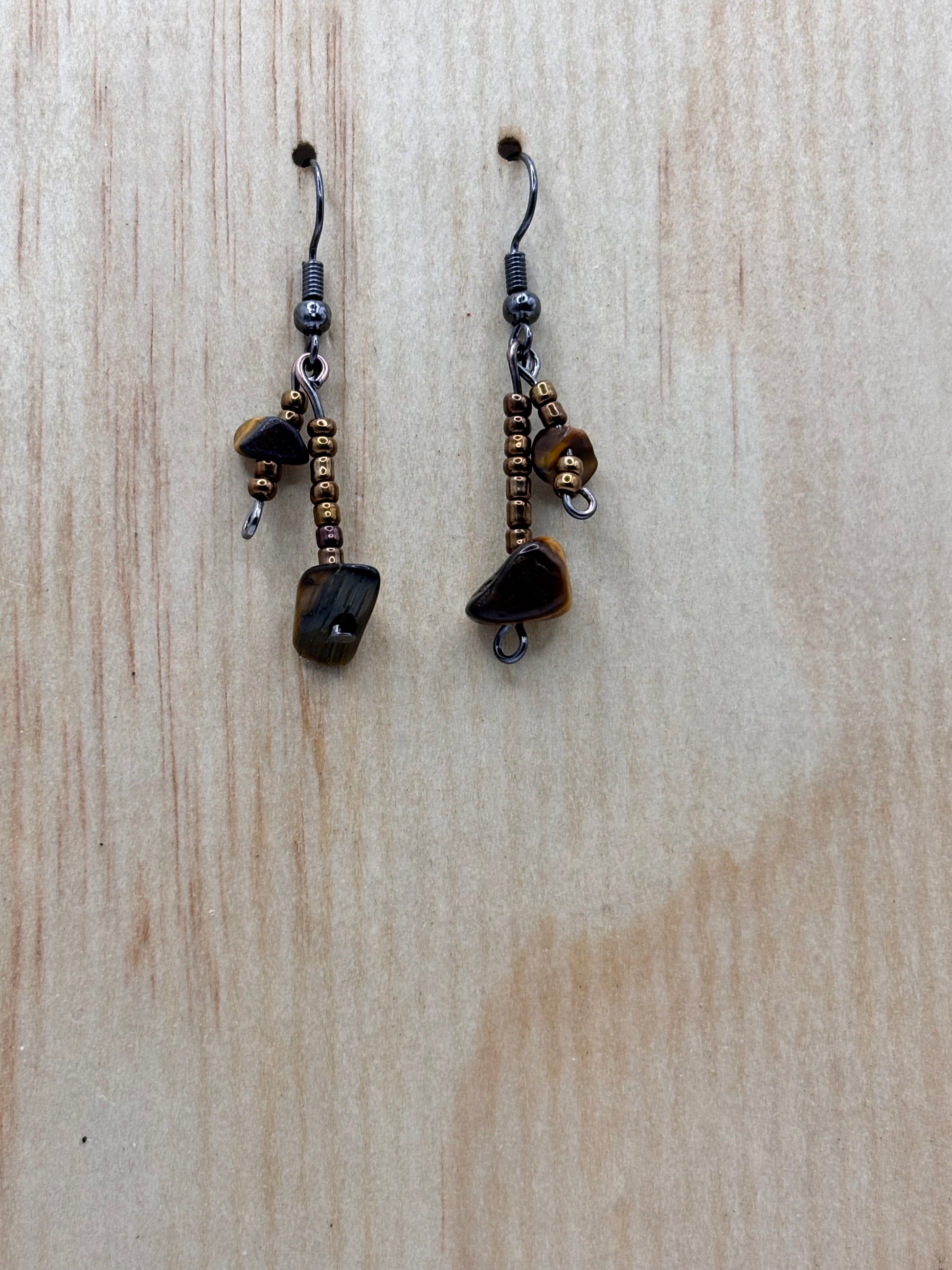 Pair of dangling earrings on a wooden surface