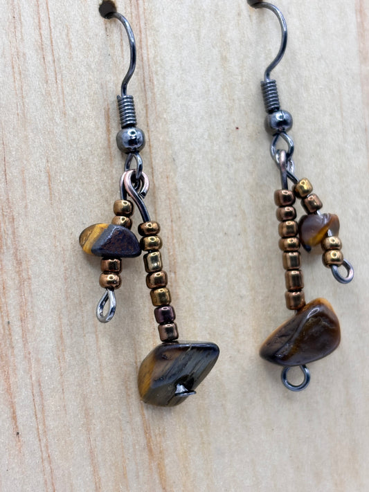 Pair of beaded earrings with natural stone accents on a wooden surface