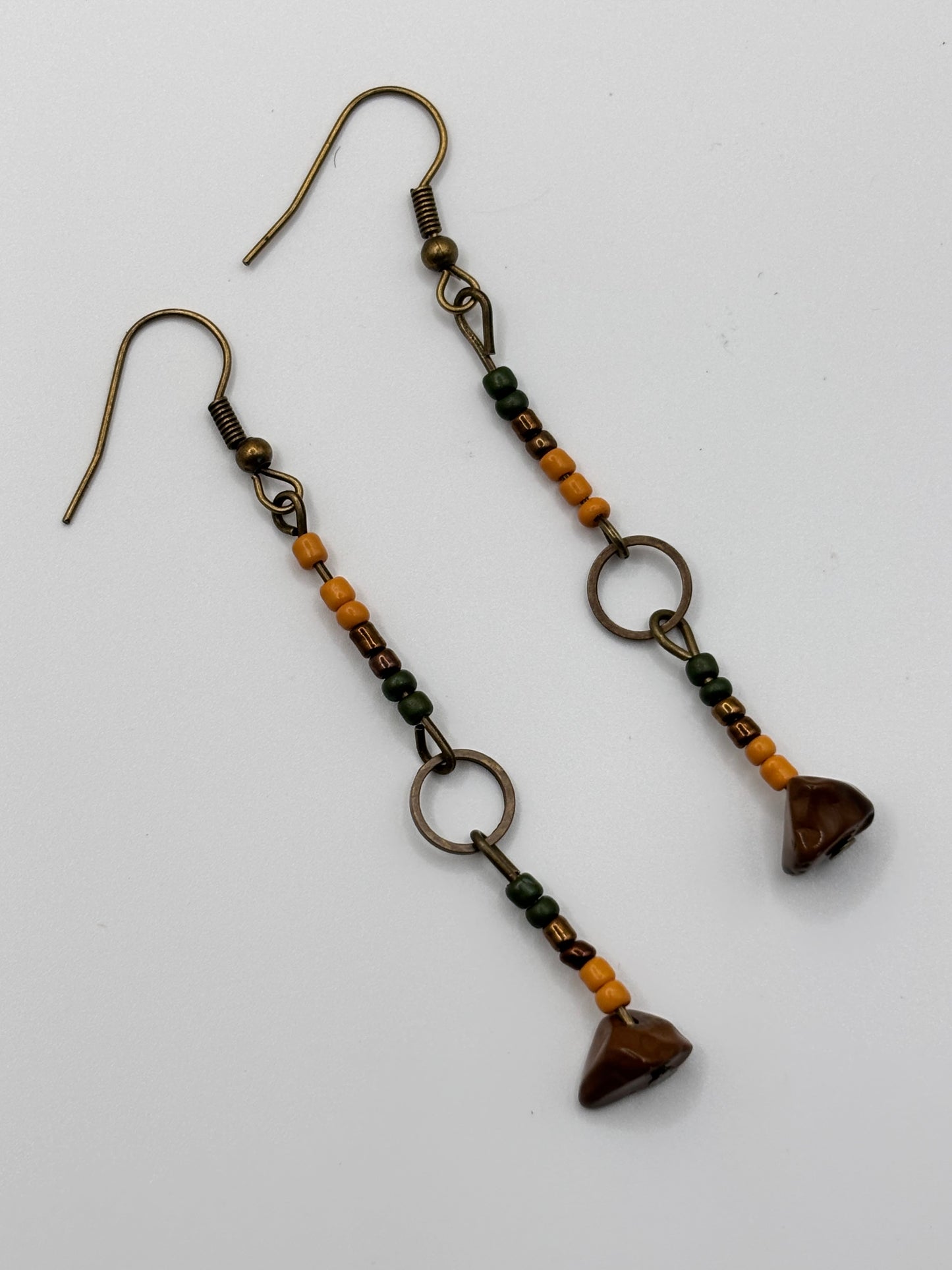 Pair of beaded earrings with heart-shaped beads on a white background