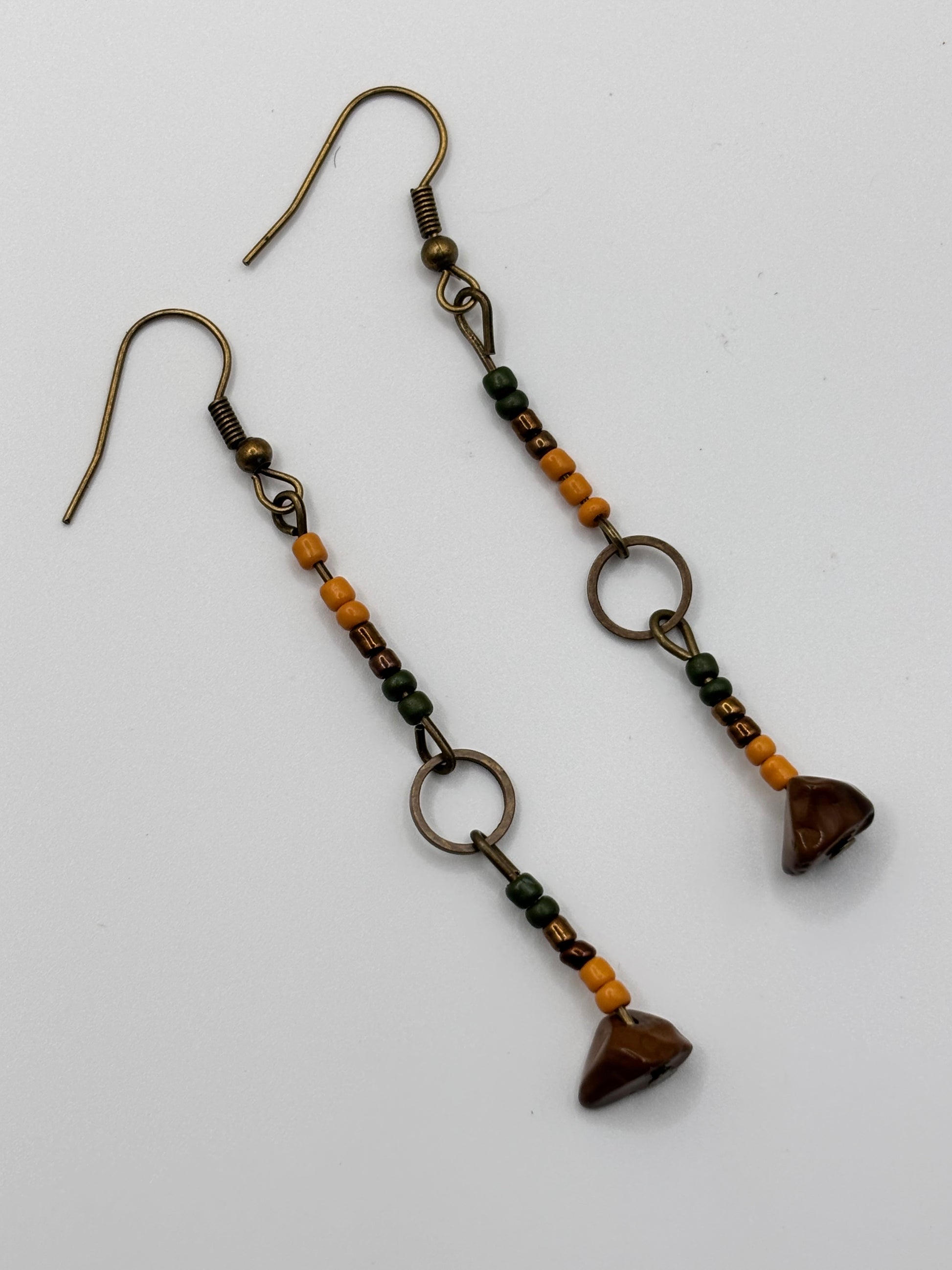 Pair of beaded earrings with heart-shaped beads on a white background