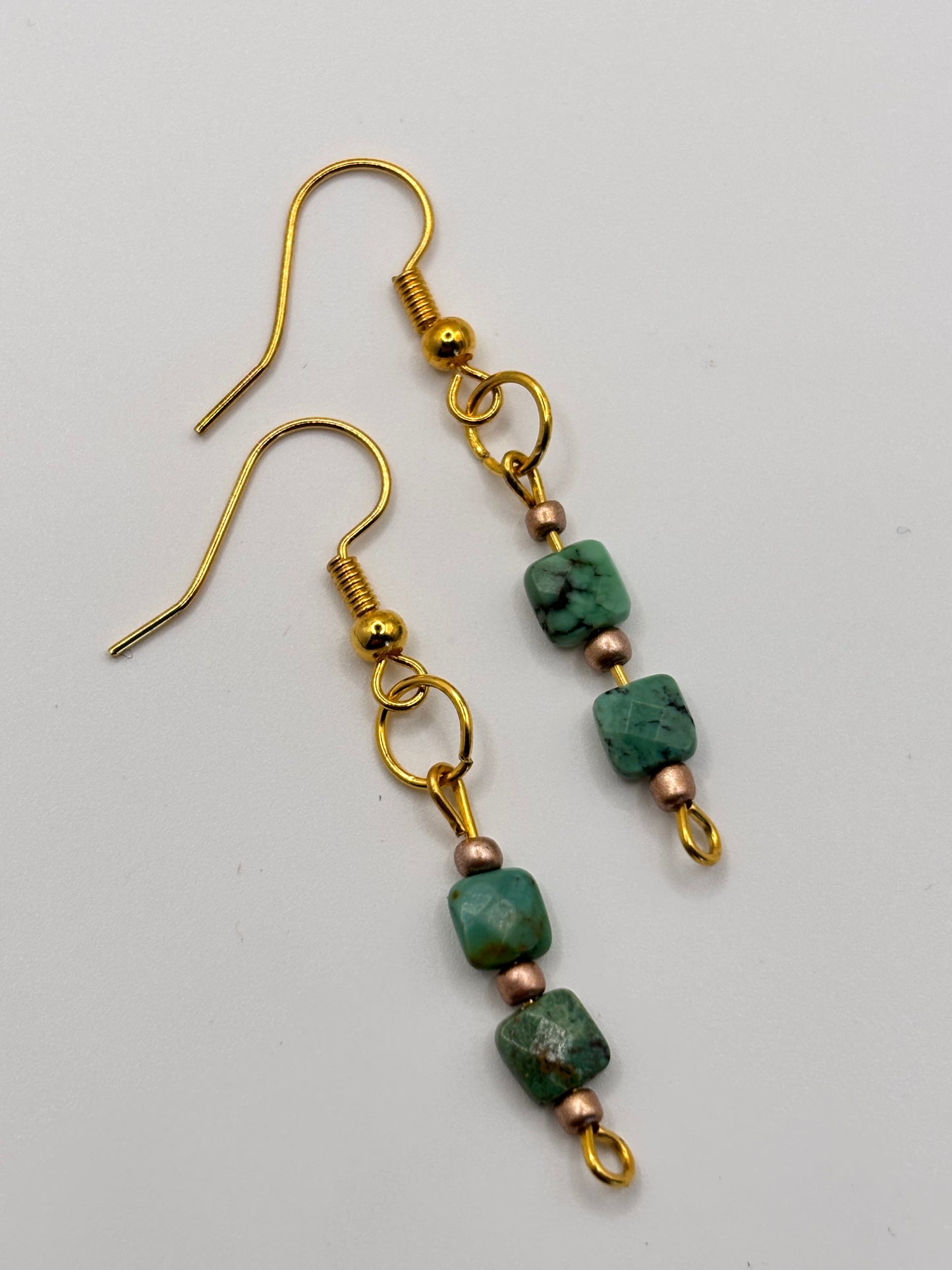 Rustic turquoise drop earrings flat lay on natural surface