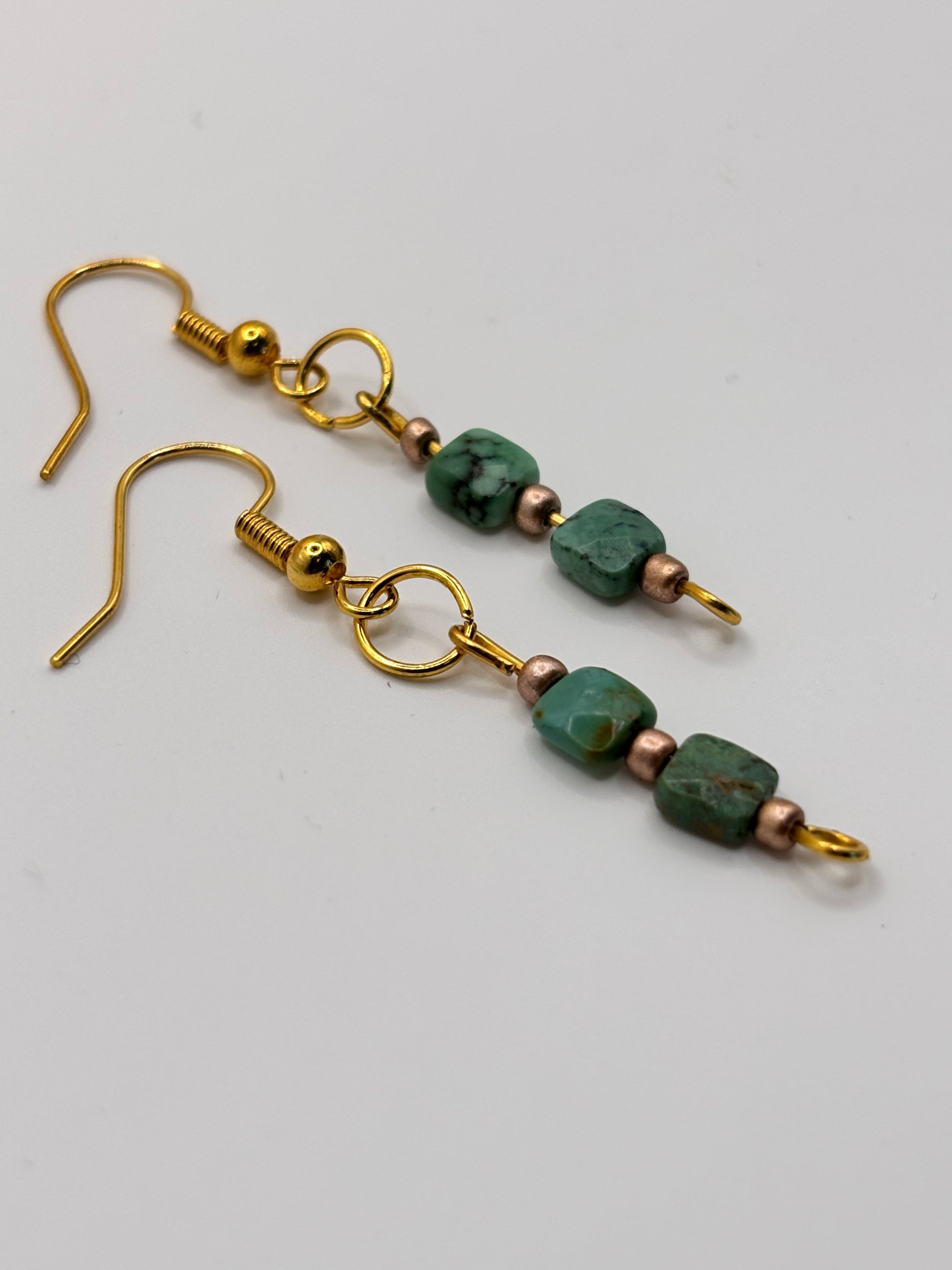 Bold turquoise dangle earrings with gold hardware close-up